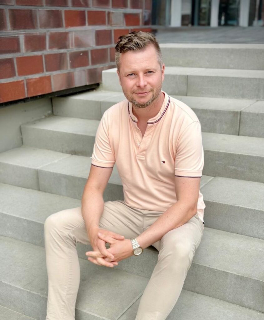 Mirko Fürst sitzt auf einer Treppe und schaut in die Kamera